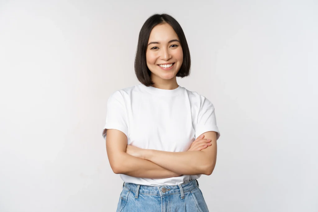 Skincare Brand Landing Page Concept portrait happy asian woman smiling posing confident cross arms chest standing against studio background.webp